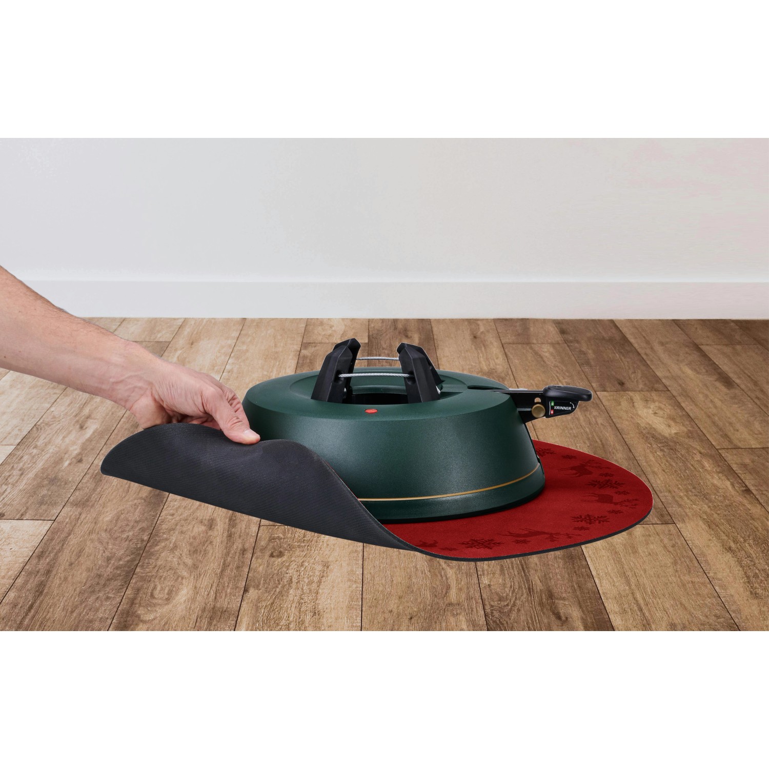 Rote Krinner Weihnachtsbaum-Unterlegdecke (Ø 60 cm) unter einem grünen Christbaumständer.