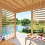 Bertilo Pavillon Garten-Lounge aus Holz, 234x226cm, mit Lamellenwand und Blick in den Garten.