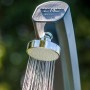 Detailaufnahme: Graue Gre Solardusche mit Duschkopf und Wasserstrahl. Ideal für den Garten.