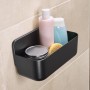 Schwarzer Tesa Lavaa Duschkorb (Small) mit Shampoo, Duschgel und Schwamm an der Wand.