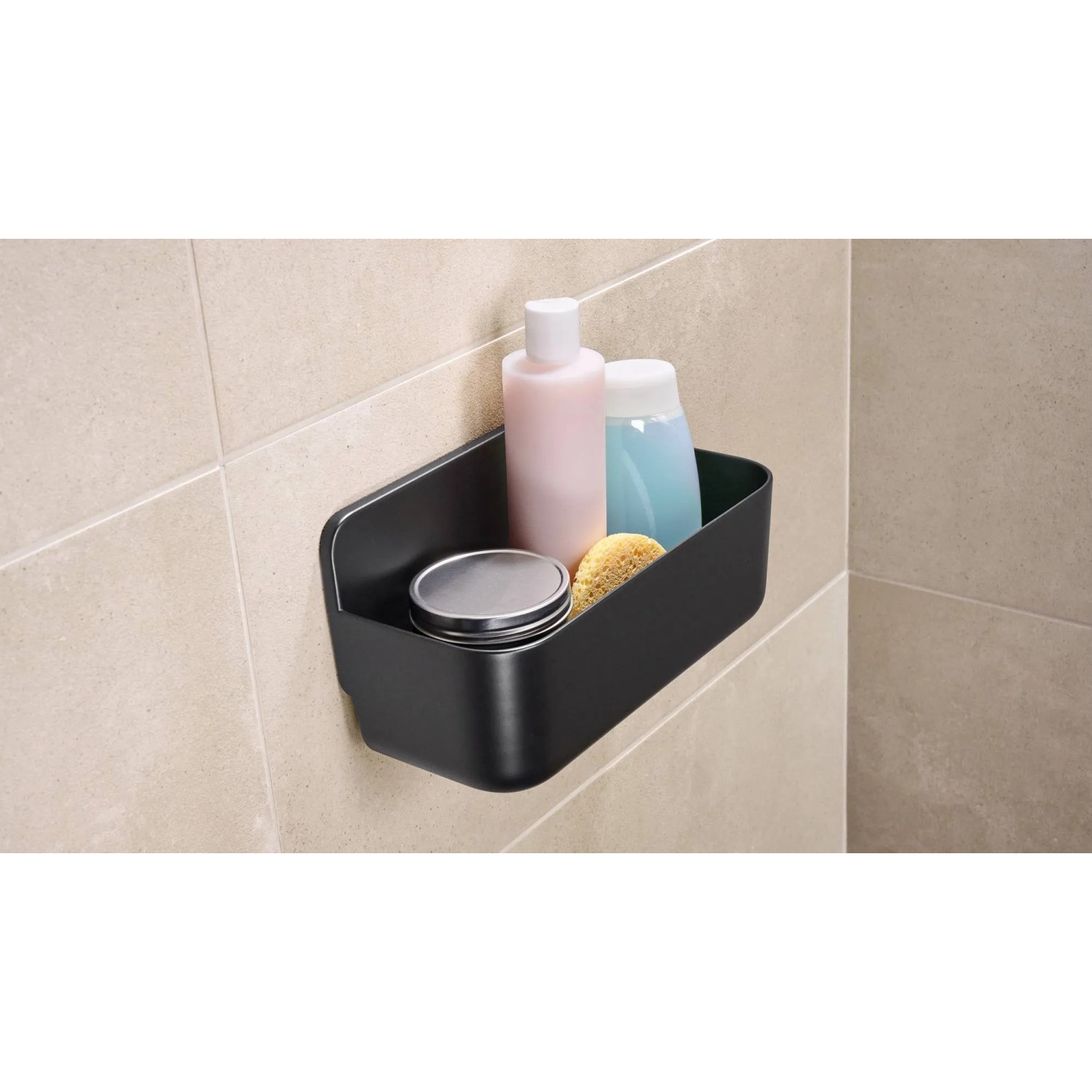 Schwarzer Tesa Lavaa Duschkorb (Small) mit Shampoo, Duschgel und Schwamm an der Wand.