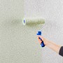 Auftragen von Knauf Compact Color Schiefer Putz mit Farbrolle auf eine Wand.