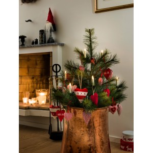 Weihnachtsbaum mit Konstsmide LED-Baumbeleuchtung und roten Herzanhängern im Innenraum.