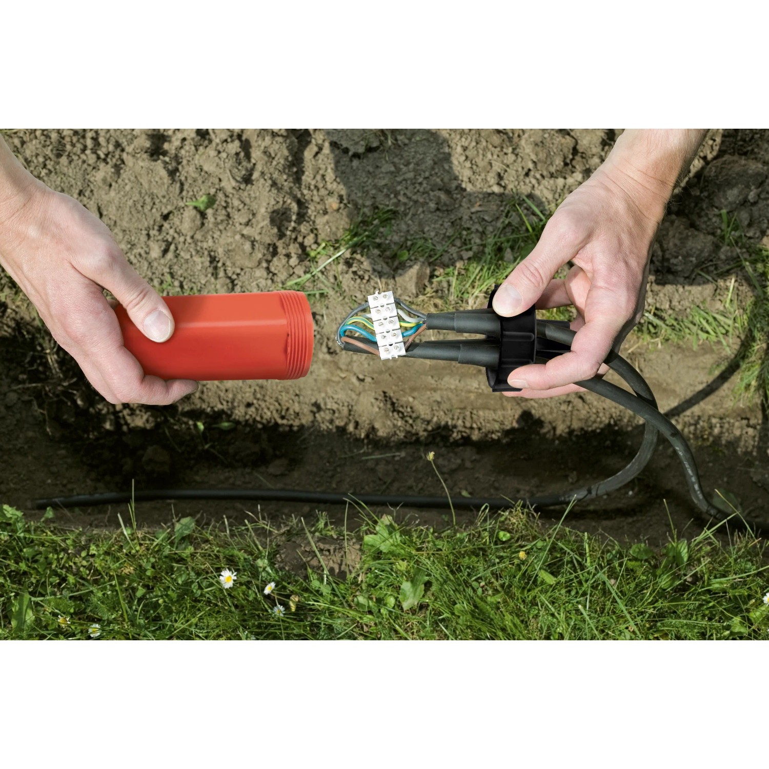 Dosenmuffen-Set IP68 im Einsatz: Kabel verbinden mit Muffe, Kabelbinder und Werkzeug im Erdreich.