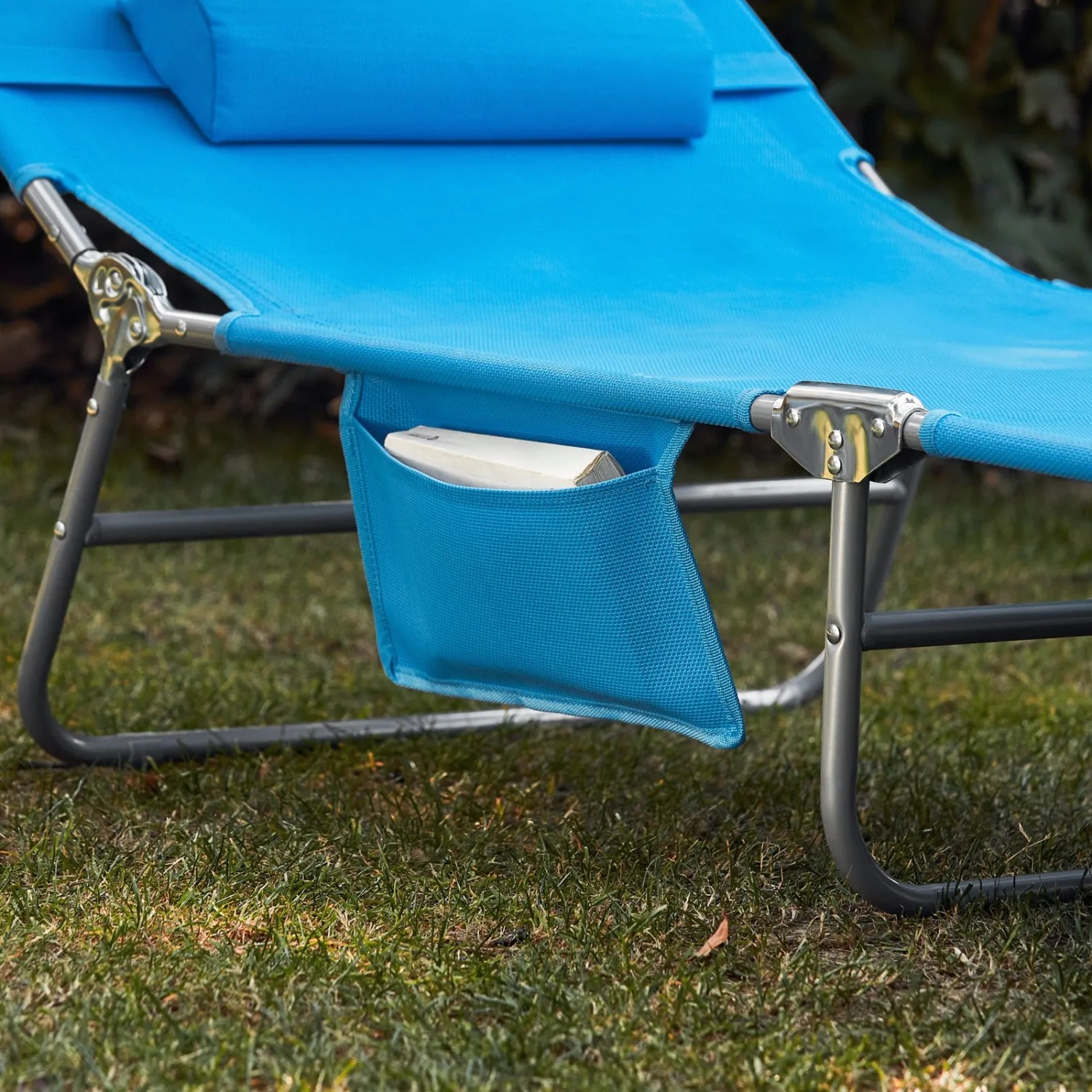 Detailansicht: Blaue SoBuy Gartenliege mit Seitentasche für Buch.