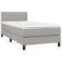 Helles Boxspringbett 90x190 cm mit Matratze und Kopfteil, Stoffbezug.