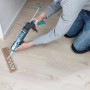 Anwendung der wolfcraft Kartuschenpresse MG 200 Ergo beim Verlegen einer Holzleiste.