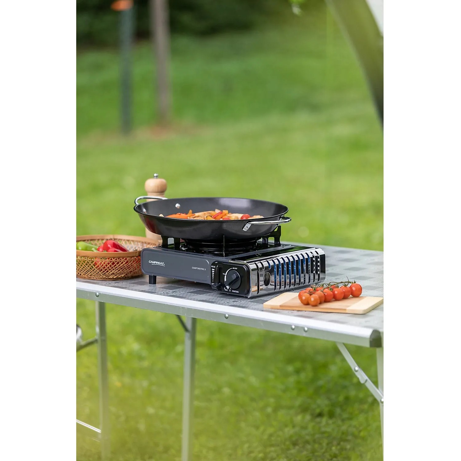 Campingaz Camp'Bistro 3 Tischkocher mit Pfanne und Zutaten auf Campingtisch.