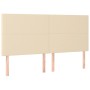Cremefarbenes Boxspringbett mit Stoffbezug, inklusive Kopfteil und Holzfüßen.