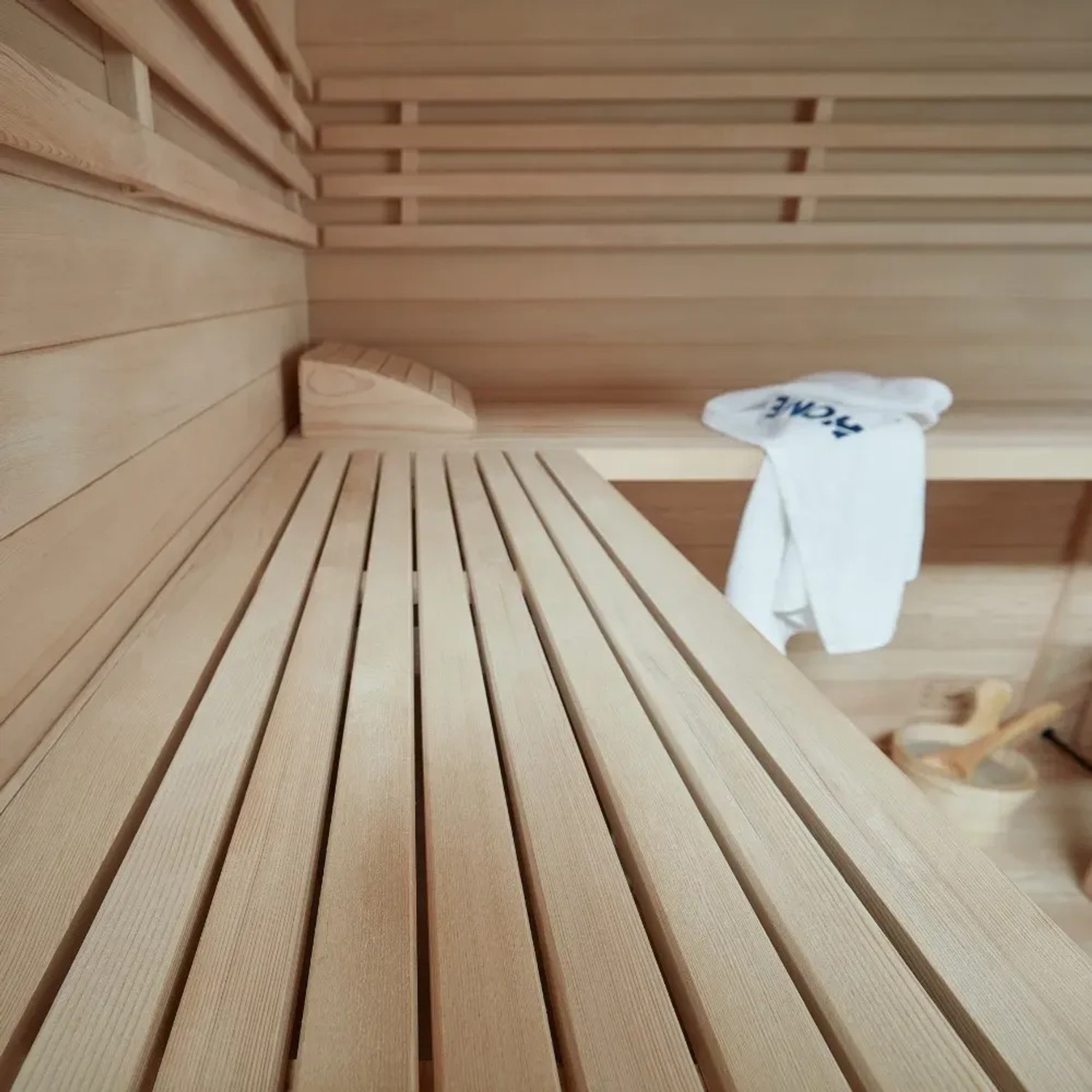 Innenansicht der SKYLINE BIG Sauna aus Tannenholz mit Bänken und Zubehör.