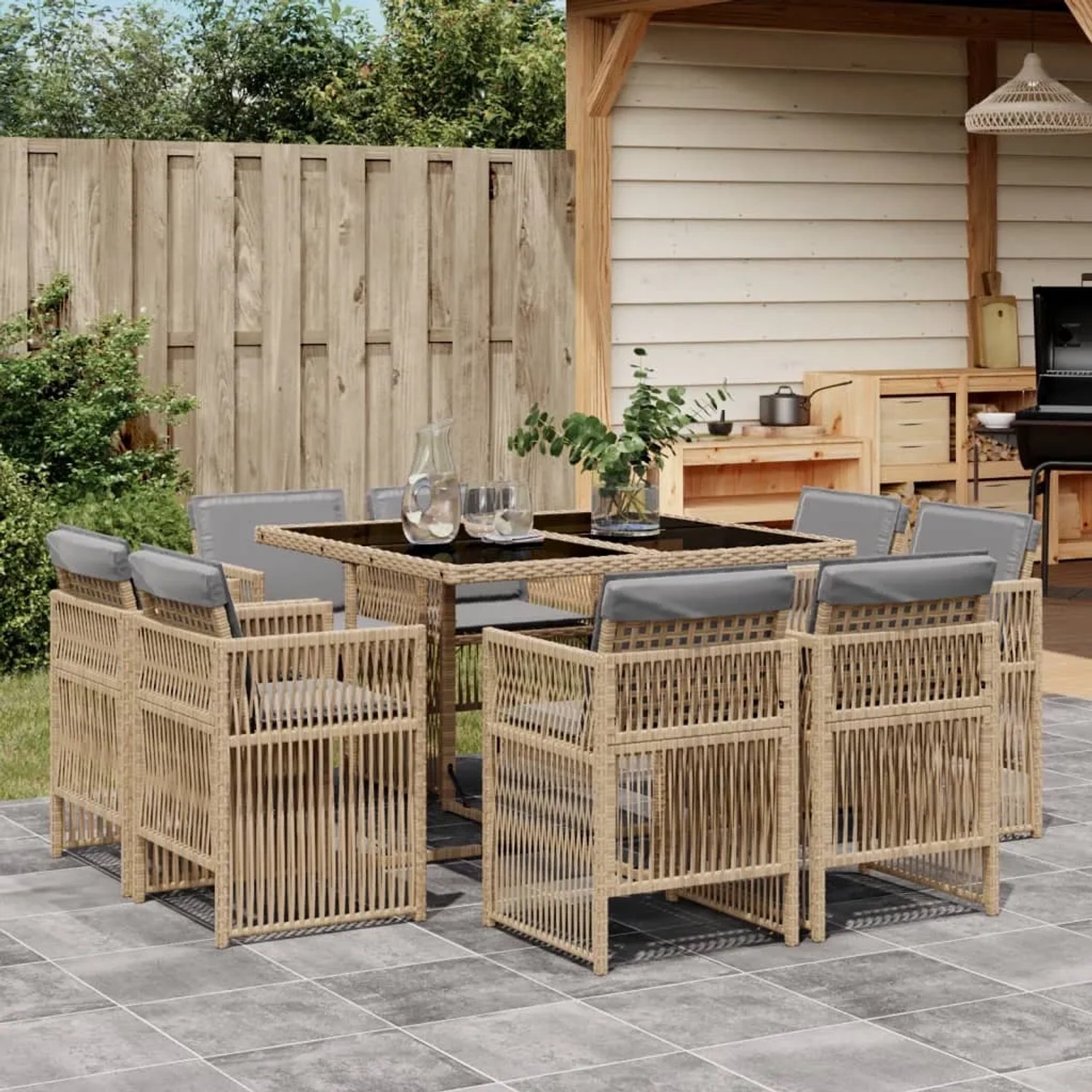 9-teilige Garten Essgruppe mit beigemischtem Poly Rattan, inklusive Tisch mit Glasplatte und Stühlen mit Kissen.