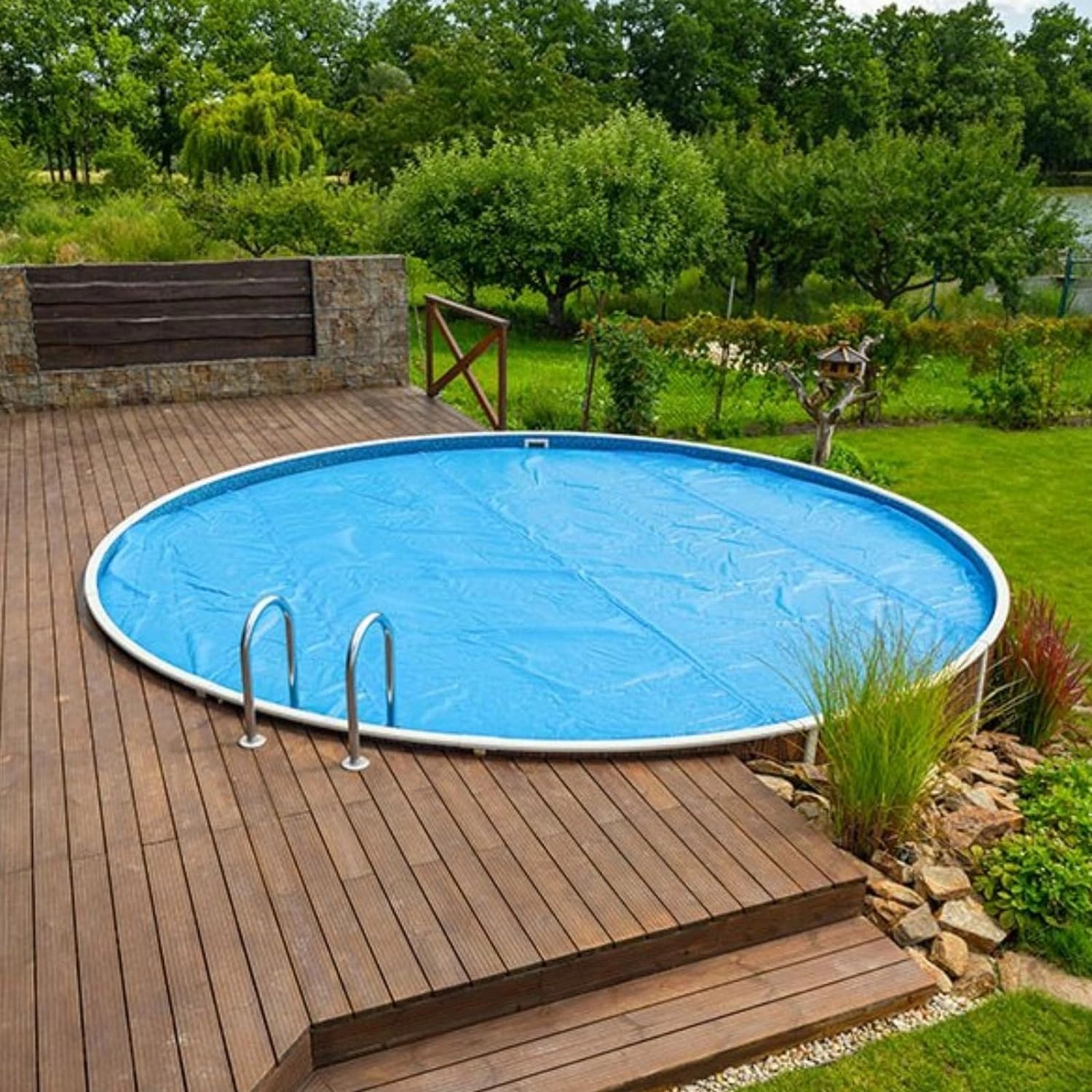 Rechteckiger Pool mit blauer poolomio Solarplane 700x400 cm auf Holzterrasse im Garten.