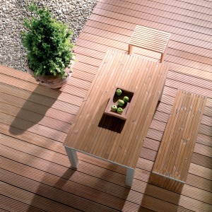 Terrasse mit Bangkirai Terrassendielen, Tisch und Bank aus Holz. Gartenmöbel auf braunem Holzboden.