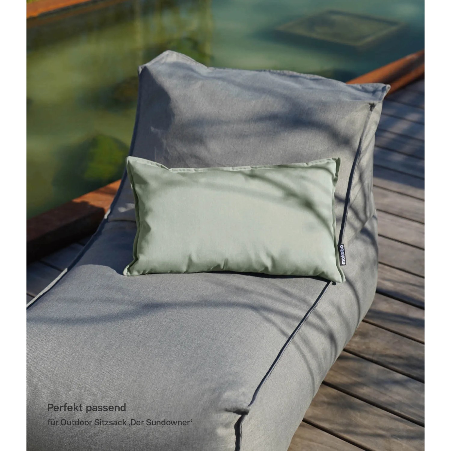 Lindgrünes mokebo Outdoor Kissen 'Ruhepolster' 50x30 cm auf grauem Sitzsack.