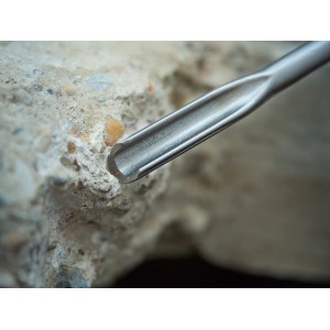 Nahaufnahme des LUX SDS-Plus Hohlmeißels (250 mm) vor einem Stein.