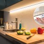 MaxLED Profilsensor Touchless in Küche mit LED-Streifen unter Hängeschrank. Hand vor Sensor.