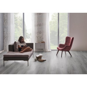 Heller Check One Click-Vinylboden Vogelsang Eiche im Wohnraum mit Sessel und Couch.