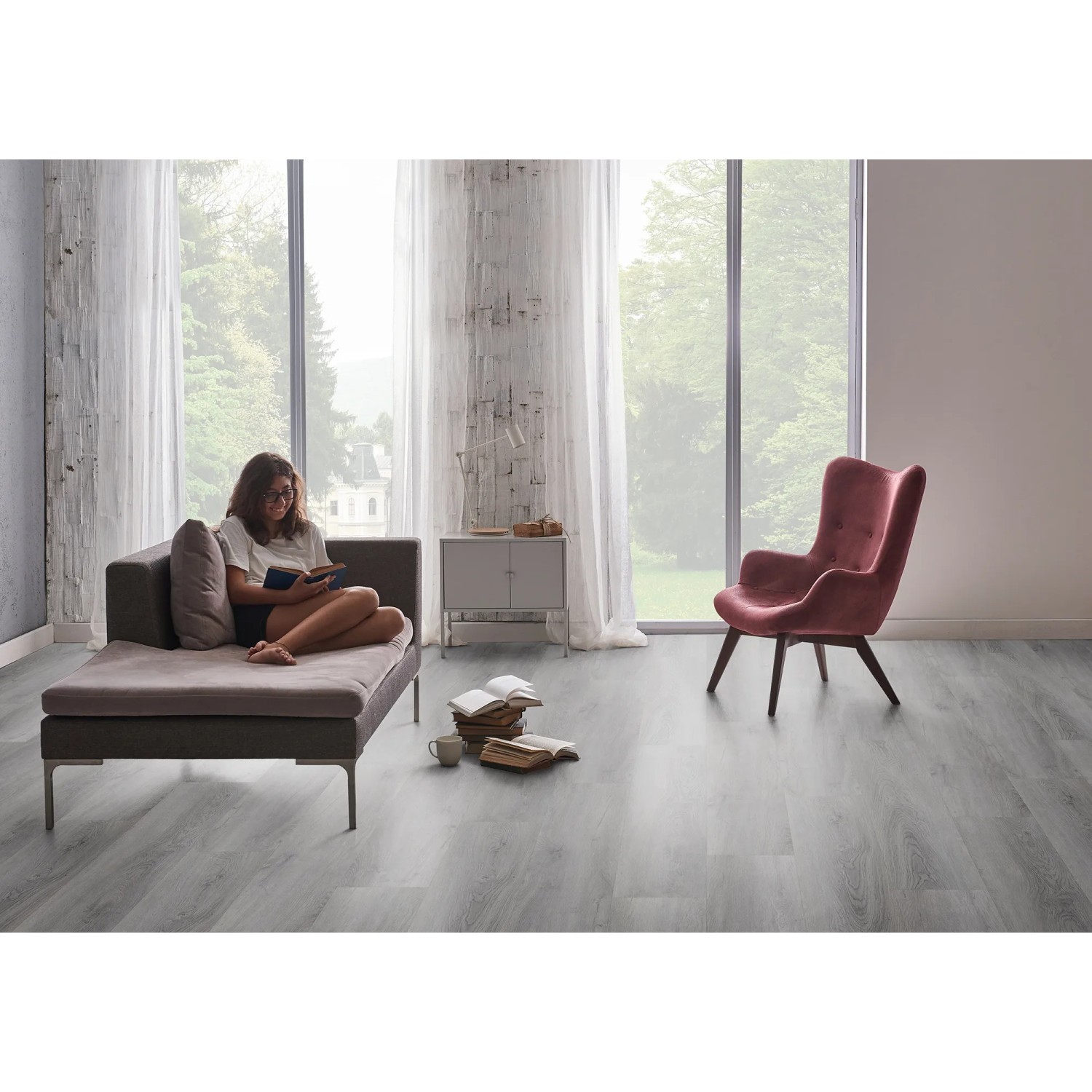 Heller Check One Click-Vinylboden Vogelsang Eiche im Wohnraum mit Sessel und Couch.