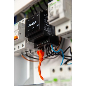 Schwarzes Shelly Pro 3 Relaismodul (3-Kanal, 48 A) mit LAN-Kabel im Verteilerkasten.