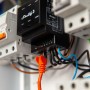 Schwarzes Shelly Pro 3 Relaismodul (3-Kanal, 48 A) mit LAN-Kabel im Verteilerkasten.