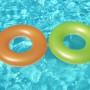 Bestway Schwimmringe, orange und grün, im Wasser. Unifarbenes Design für Badespaß.
