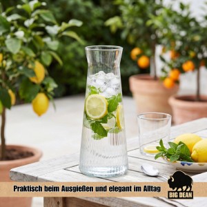 Stilvolle geriffelte 1L Wasserkaraffe aus Glas mit Zitrone, Minze, Eis auf Holztisch. Spülmaschinenfest für Getränke.
