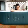 Bestway LAY-Z-SPA Ibiza AirJet Whirlpool, dunkelgrün, eckig, mit Frau im Pool.