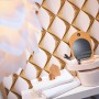 Gold-weiße 3D Vliestapete mit glänzender, leicht strukturierter Oberfläche im Badezimmer.