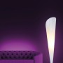 Weiße Näve Stehleuchte Tulip im Design-Stil neben lila Sofa. Modern und elegant.