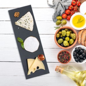 Rechteckige anthrazitfarbene Schieferplatte mit Käse, Nüssen und Basilikum. Ideal als Servierplatte für Snacks.