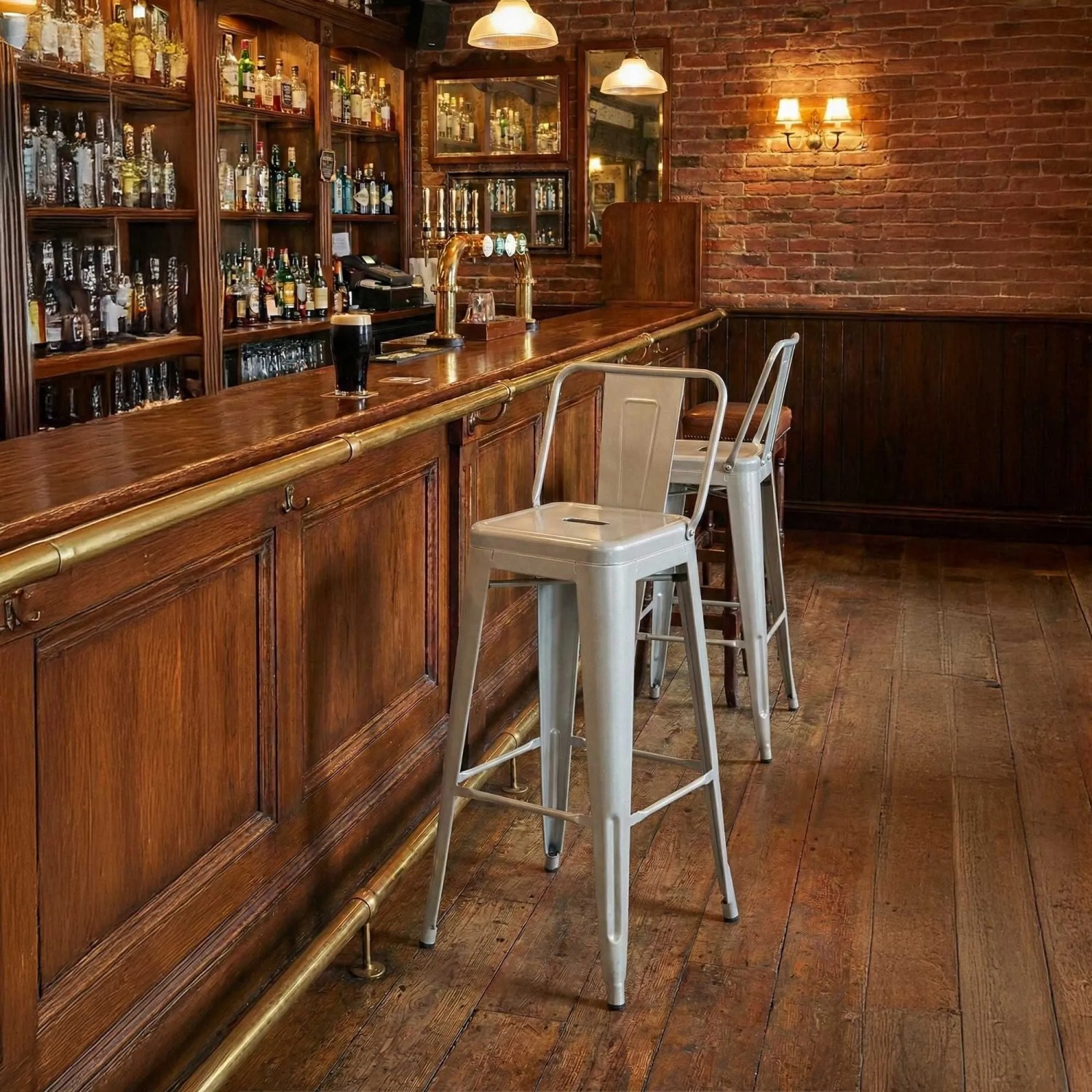 Zwei silberne Mason Barhocker aus Metall mit Rückenlehne an einer Holzbar. Ideal für Küche & Gastronomie.