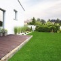 Sonniger Garten mit Karat Kunstrasen Lemon 50mm, ideal für entspannte Stunden im Freien.