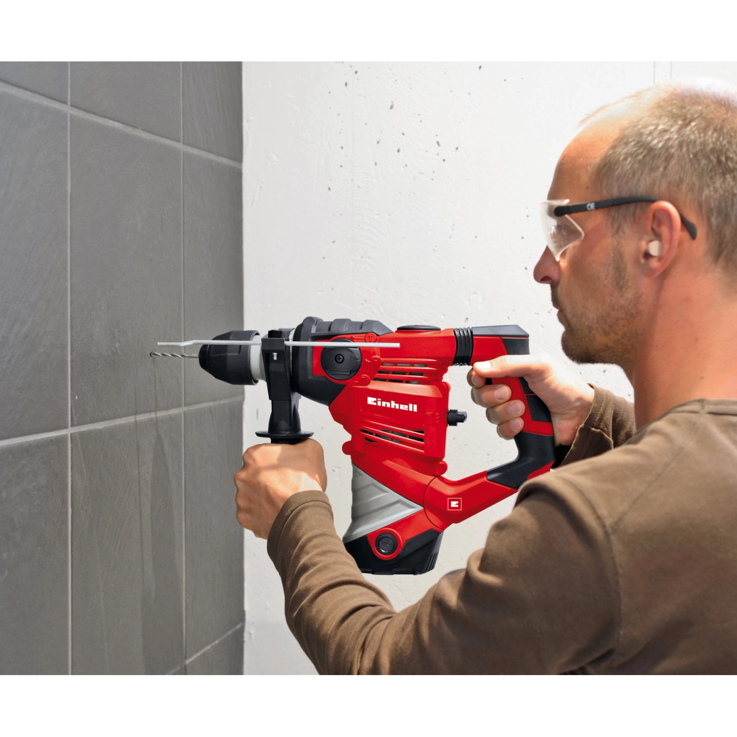 Einhell Bohrhammer TC-RH 900 in Nutzung, rot/schwarz, mit Tiefenanschlag und Koffer.