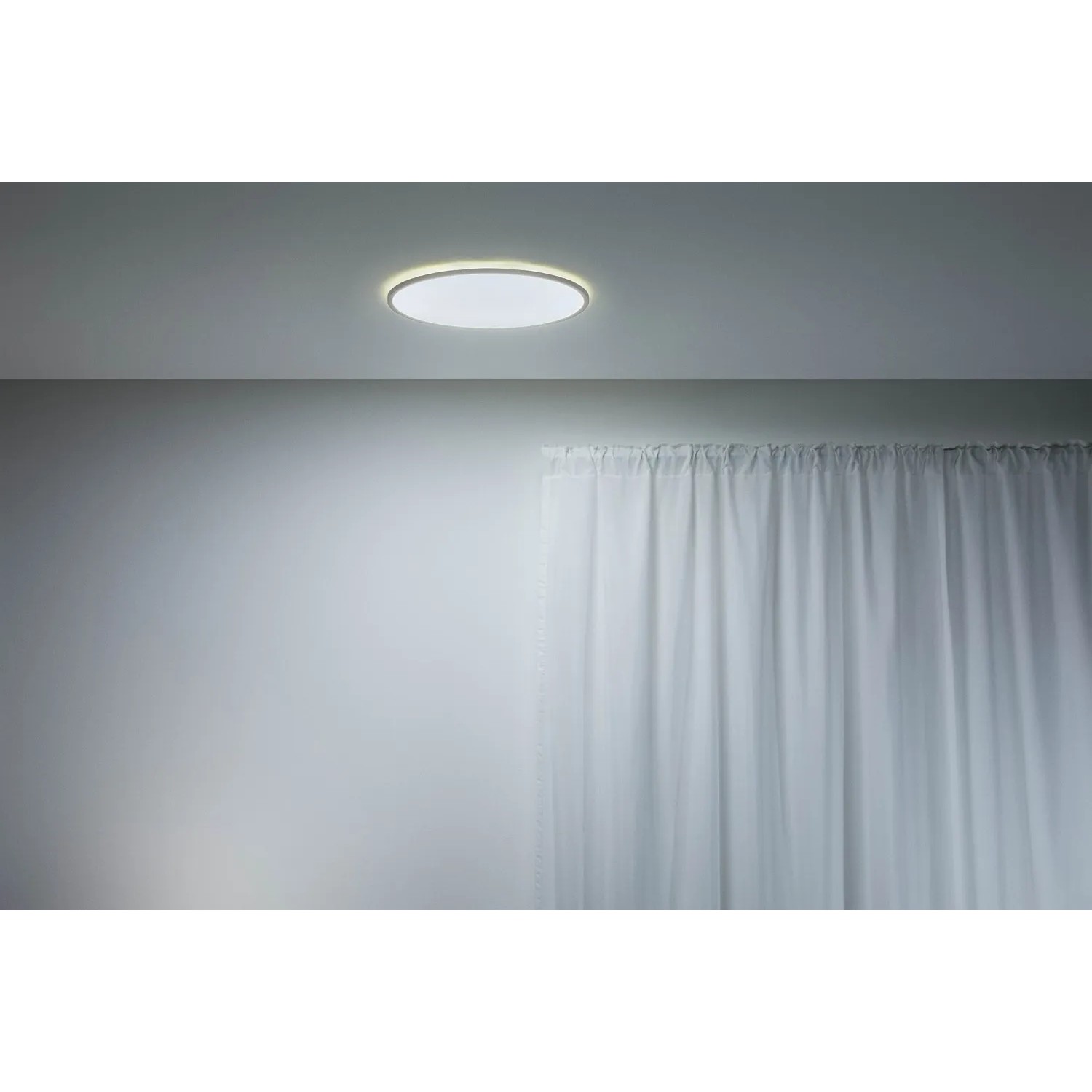 Weiße, runde WiZ LED-Deckenleuchte SuperSlim mit warmweißem Licht, montiert an einer Decke.