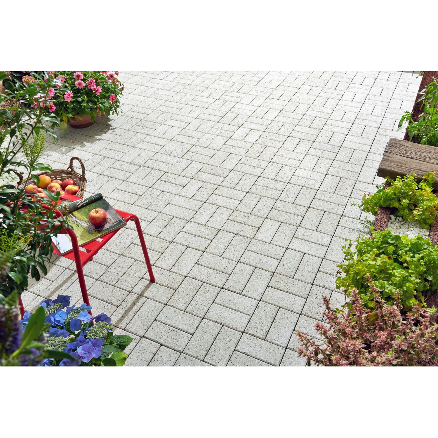 Verlegtes Rechteck-Pflaster Beton, weiß gewaschen, 20x10x6 cm, auf Terrasse mit Bepflanzung.
