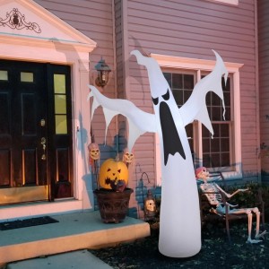 Großes, weißes, aufblasbares Halloween-Gespenst mit leuchtenden Augen und Mund vor einem Haus. Gruselige Deko.