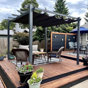 Dunkelgraue Aluminium Pergola mit schwarzem Schiebedach auf Holzterrasse. Bietet Sonnenschutz für Outdoor-Sitzbereich im Garten.