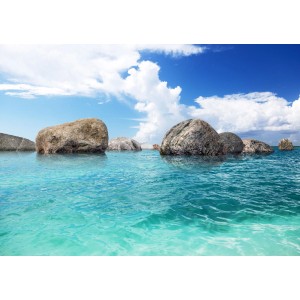 Sanders Fototapete Meerblick: Türkisblaues Wasser mit Felsen unter blauem Himmel.