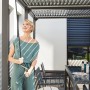 Frau bedient Kurbel am Home Deluxe Pavillon Cannes mit Lamellendach.