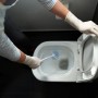 Person reinigt Toilette mit Vileda Einweghandschuhen Natural Latex Extra Long.