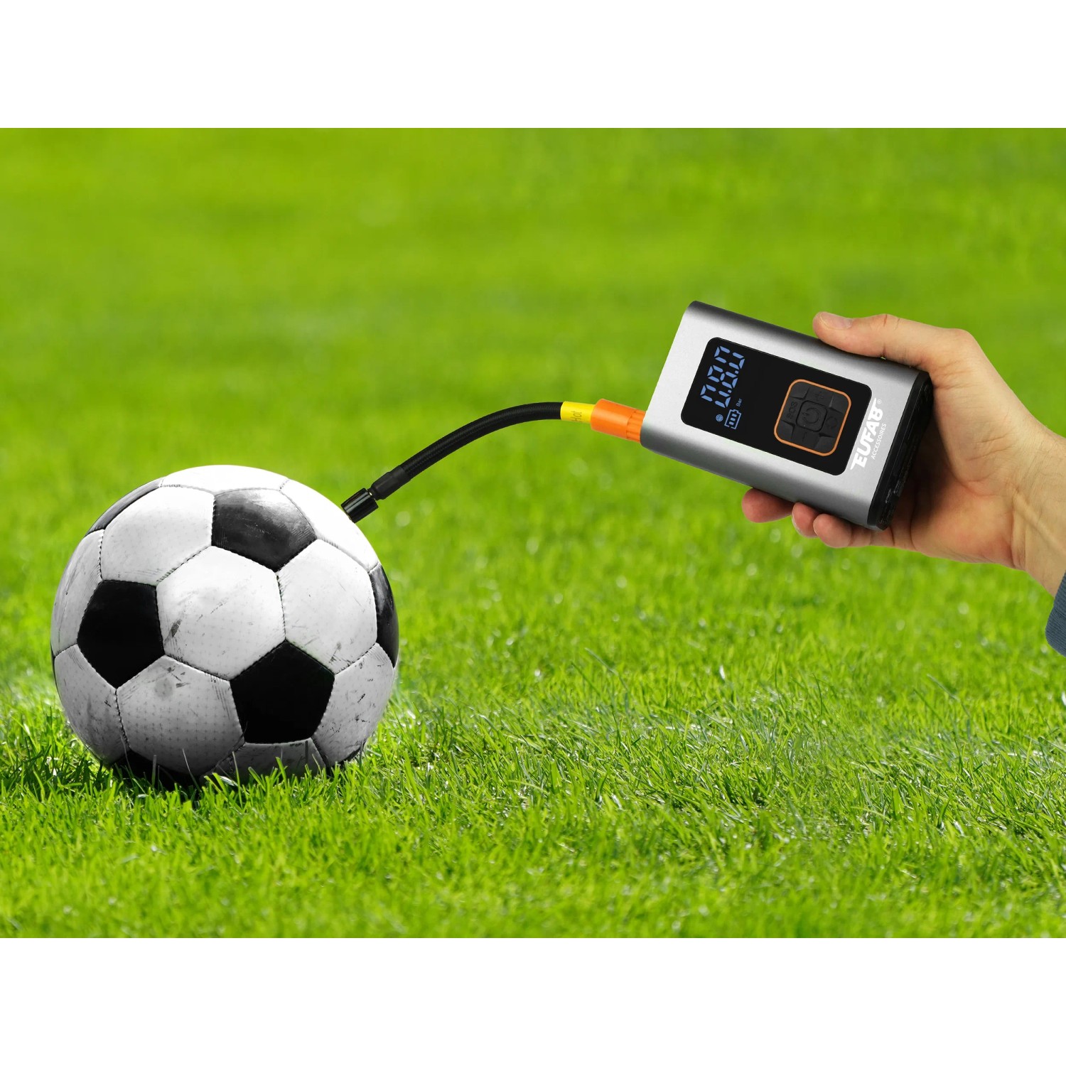 Eufab Mini-Kompressor (aufladbar) beim Aufpumpen eines Balls auf Rasen.