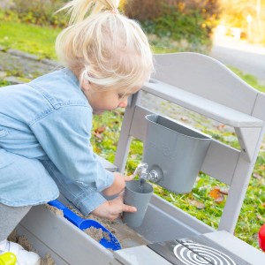 Kind spielt mit grauer roba Outdoor Spielküche aus FSC-Holz mit Wasserhahn und Zubehör.