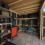 Gartenhaus Bertilo HPL Italian Walnut (345x229cm) mit Fahrrad, Grill und Werkzeugwagen im Innenraum.