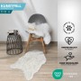 Flauschiges, elfenbeinfarbenes KARAT Kunstfell Nelly als Dekofell auf Stuhl und Boden.