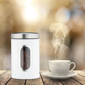 Weiße Relaxdays Vorratsdose aus Metall mit Sichtfenster und Kaffeebohnen, daneben eine Tasse Kaffee.