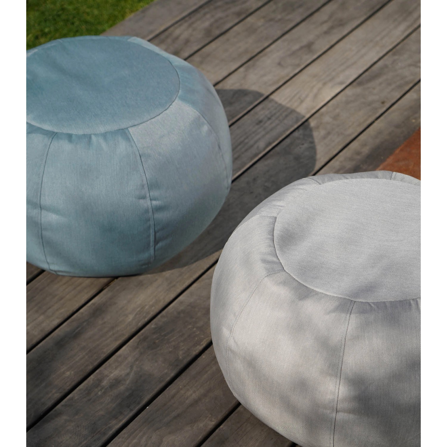 Zwei mokebo Outdoor Poufs 'Der Kugelige' in Hellgrau und Blau auf einer Holzterrasse.