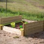 Quadratischer Wendi Toys Sandkasten aus Holz mit Abdeckung und Sitzfläche. FSC®-zertifiziert.