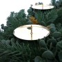 Nahaufnahme eines künstlichen Tannenkranzes mit goldenem Kerzenhalter und Zapfen für Weihnachtsdekoration.