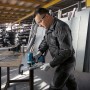 Mann schneidet mit blauer Bosch Professional Akku-Stichsäge eine Metallplatte auf einer Werkbank.