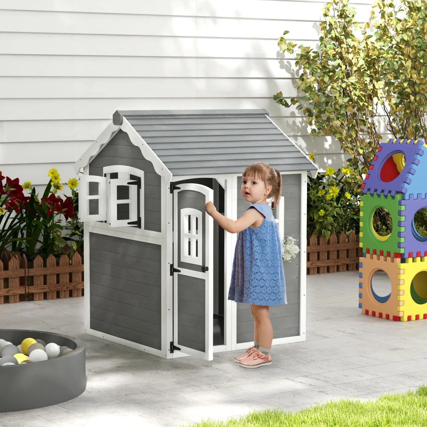 Outsunny Kinderspielhaus aus Holz mit Pflanzkasten und spielendem Kind im Garten.